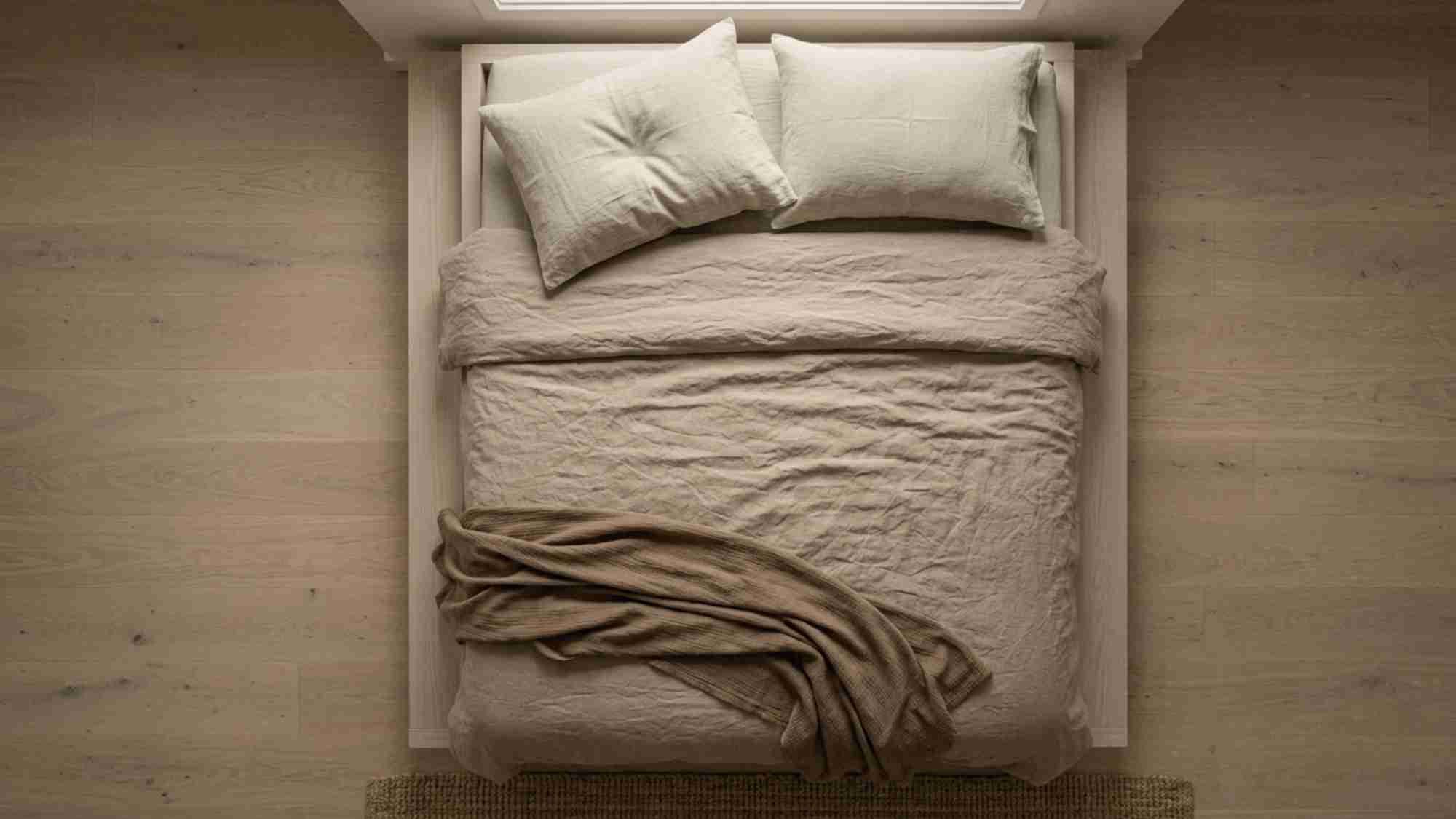 Japandi bedroom ideas for bed styling with washed sand linen duvet, undyed pillow cases, and a single folded cotton throw at the foot of the bed