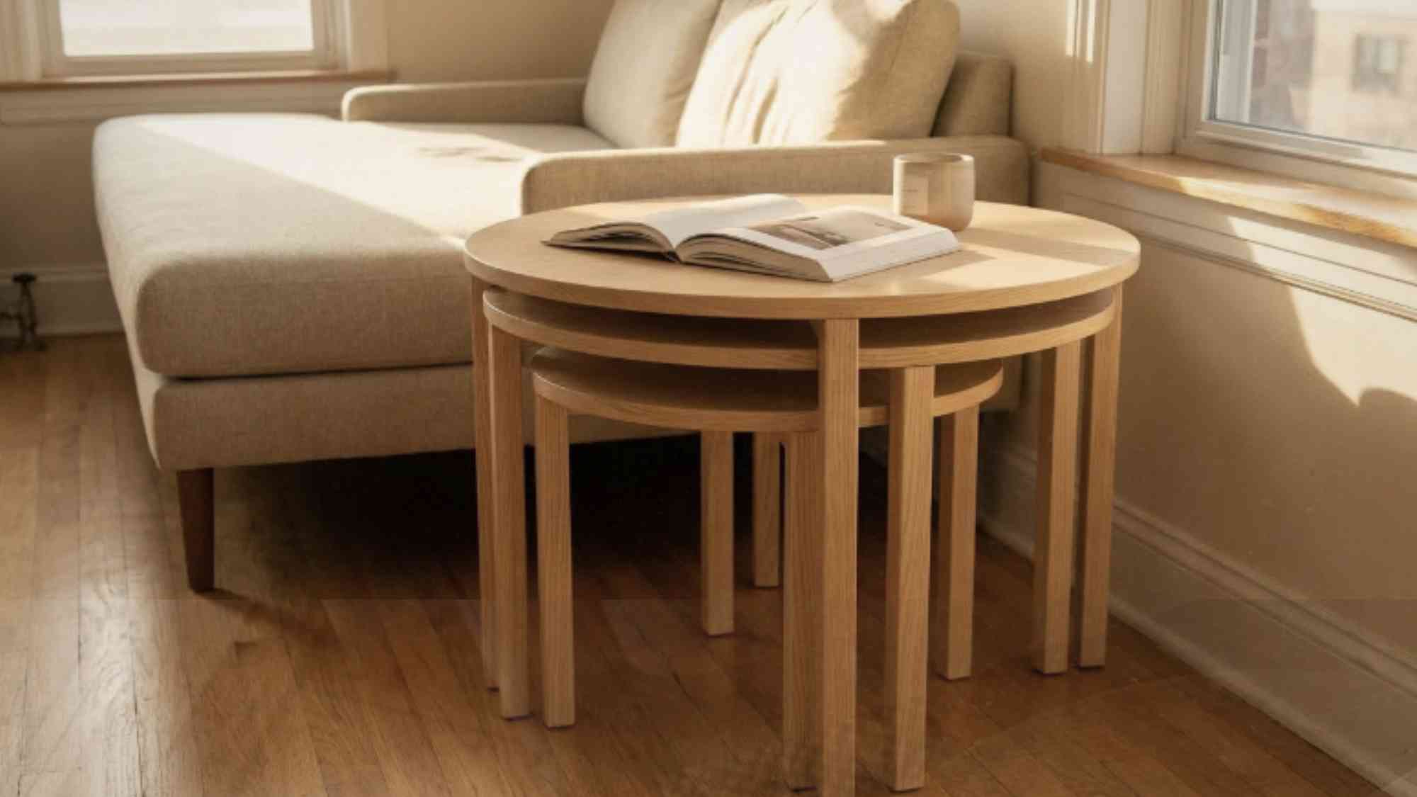 Set of three round ash wood nesting tables in a small apartment living room tucked together to save floor space